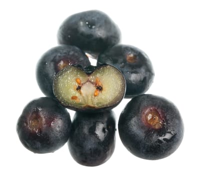Stack of blueberries with one sliced through the center to show seeds