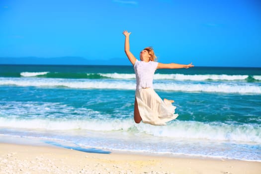 Young woman jumping on the tropical beach