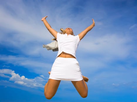 Girt is jumping over cloudy sky background