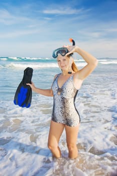 Young woman with snorkeling equipment near ocean