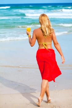Woman with juice on the tropical beach