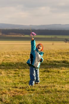 Boy pointing to the sky with a stick