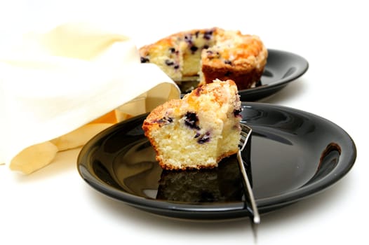 Slice of fresh baked Blueberry Ring Cake served on a black plate with a light colored background