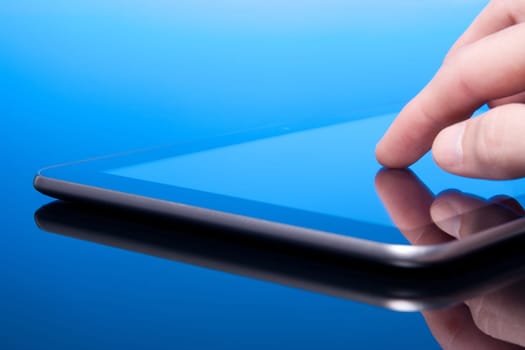 Man working with tablet computer (blue tint). Touching screen on tablet PC.