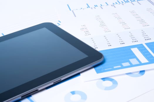 Modern business analysis with digital tablet computer, sheet and graphs.