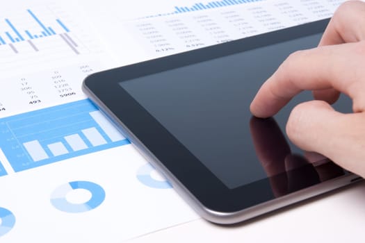 Modern business analyst working with digital tablet computer, sheet and graphs.