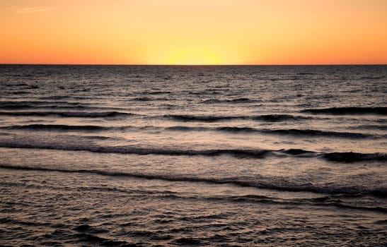 sun is setting over the sea at semaphore south australia