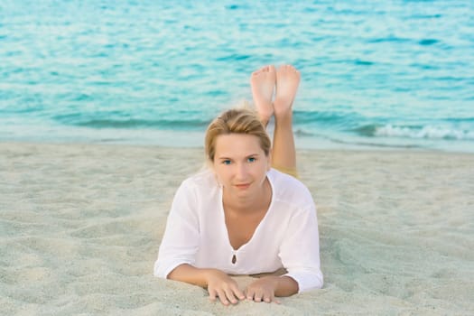 Young woman relaxing near ocean on sandy beach