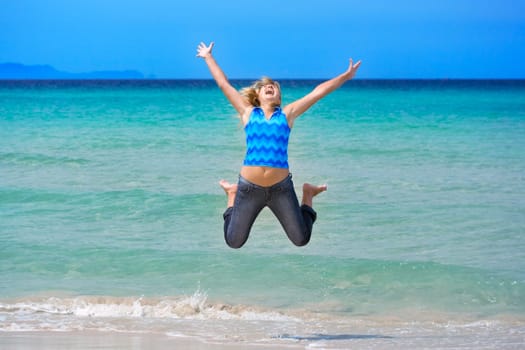 Young woman jumping on the tropical beach