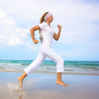 Young woman running near the ocean