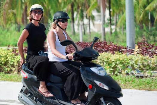 Two tourist woman riding motorbike on road. Vietnam