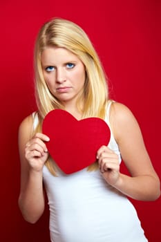 Young blonde woman with red heart in hands