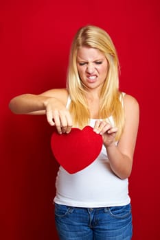 Young blonde woman with red heart in hands