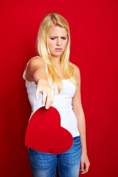 Young blonde woman with red heart in hands