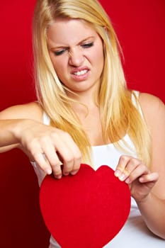 Young blonde woman with red heart in hands