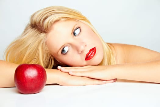 Young beautiful laughing girl with apple against white background