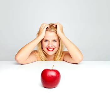 Young beautiful laughing girl with apple against white background