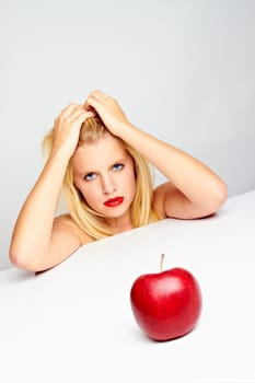 Young beautiful laughing girl with apple against white background