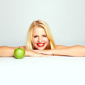 Young beautiful laughing girl with apple against white background