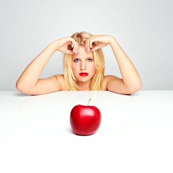 Young beautiful laughing girl with apple against white background