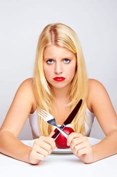 Happy young woman eating fruit with cutlery