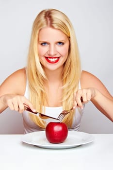 Happy young woman eating fruit with cutlery