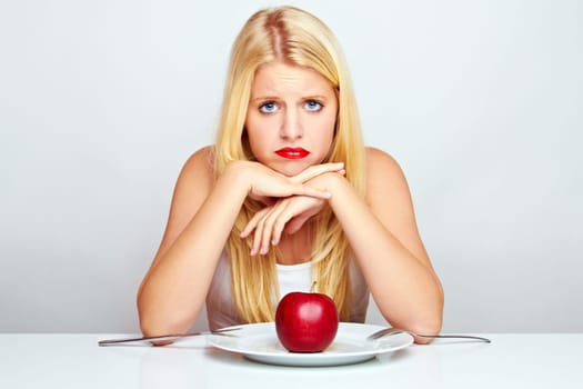 Happy young woman eating fruit with cutlery