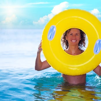 Funny woman with life buoy in the ocean