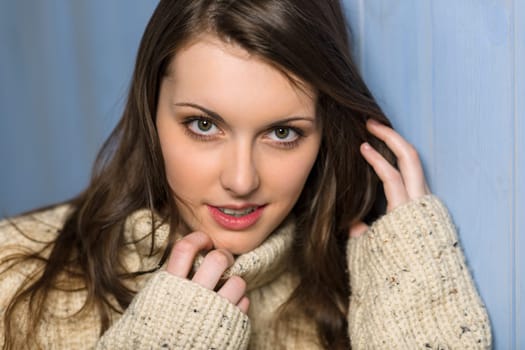 Beautiful smiling winter woman wearing beige sweater portrait