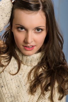 Portrait of young beautiful woman wearing winter beige sweater