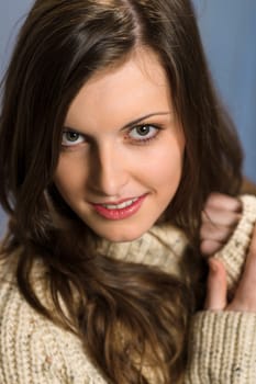 Beautiful smiling winter woman wearing beige sweater portrait