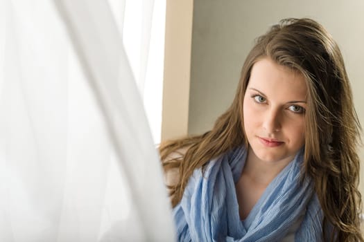 Young woman brunette stand behind blowing curtain romantic purity