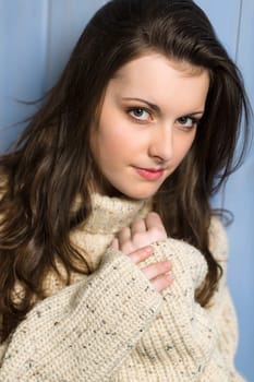 Portrait of young beautiful woman wearing winter beige sweater