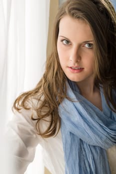 Romantic portrait beautiful woman brunette looking camera behind white curtain