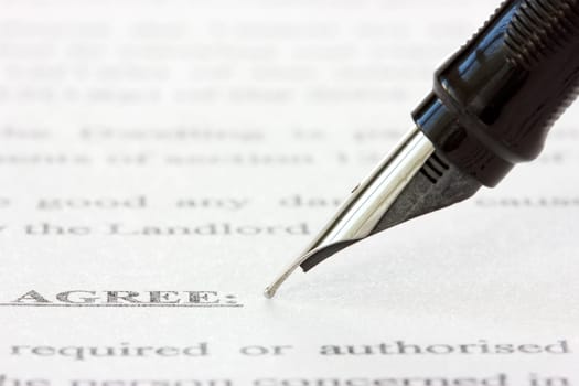 black ink pen over a printed agreement