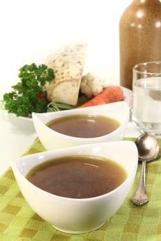 two bowls of beef consommé on a napkin