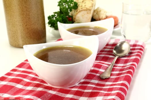 two bowls of beef consommé on a napkin