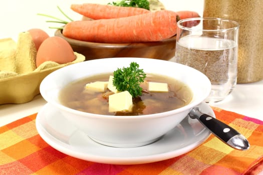 a bowl of beef consommé with egg custard and parsley