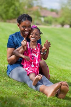 Portrait of a adorable african mother with her daughter in the garden