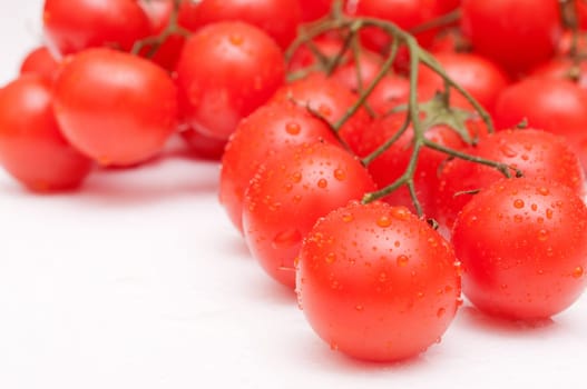 Closeup of Bunch of Fresh Cherry Tomatoes on White Table