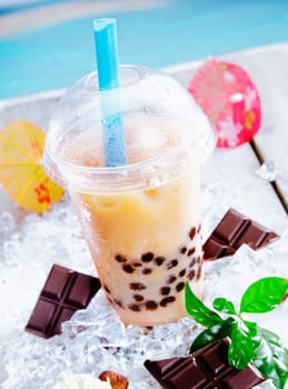 Refreshing sherbet drink with bits of chocolate served in a domed cup with a straw on a hot day