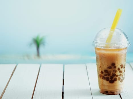 Inviting iced drink in a covered cup on a warm day at the seashore.