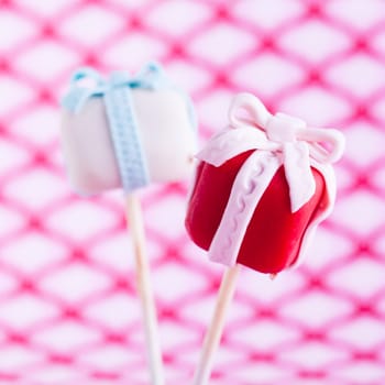 Delicious coluored Cake pop as a gift with a trendy background