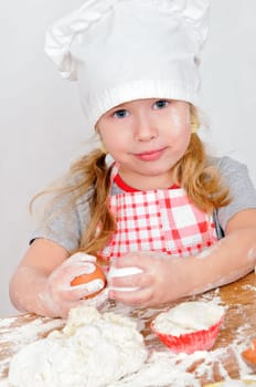 girl in chef&#039 s hat cooking dough for cake
