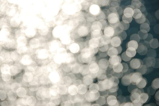 Light shining on sea water. Blurry reflections on sunny day abstract background.