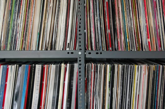 Vinyl music records storred on metal shelves.