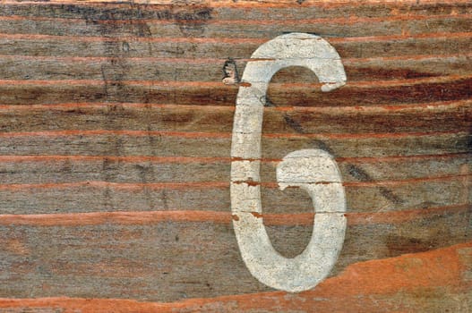 Old wooden board with number six faded stencil. Wood grunge background.