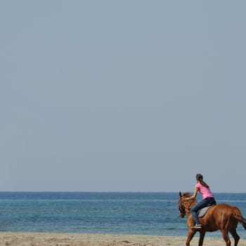KYLLINI, GREECE - MAY 2: Young woman horse riding on empty beach, Kyllini Greece, May 2, 2012.