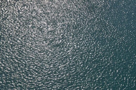 Sunshine on sea water. Light reflection on bright day ocean background.