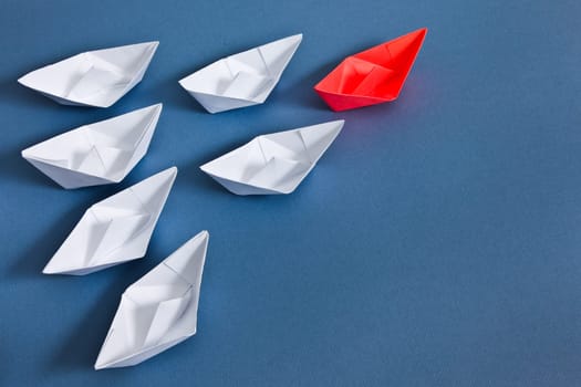 White paper boats and one red boat.
